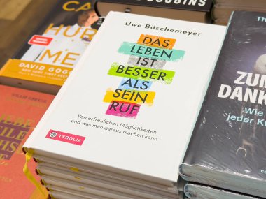 Renkli kapak tasarımlarıyla sergilenen bir yığın Almanca kitap.