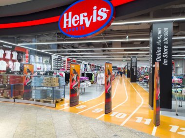 Hervis spor mağazasının içi spor kıyafetleri ve ayakkabı vitriniyle dolu..