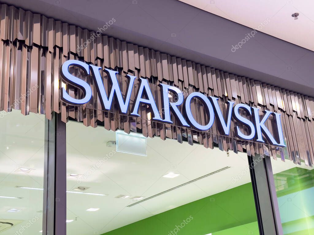 Swarovski storefront sign in modern shopping mall exterior.