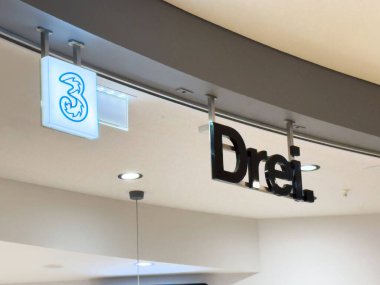 Modern alışveriş merkezinin içinde logosu olan Drei mağaza vitrini tabelası..