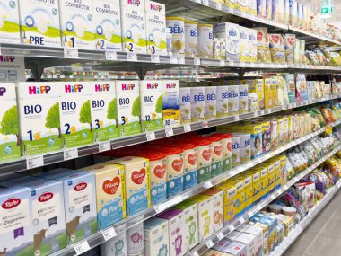 Süpermarket koridorunda çeşitli bebek mamaları gösterimi.