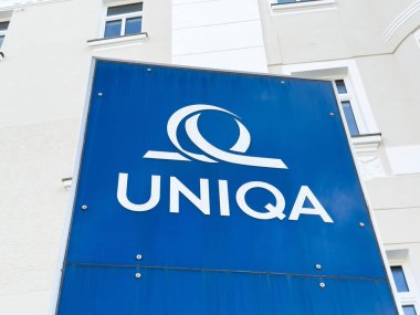Pencereli dış bina üzerinde mavi uniqa işareti.
