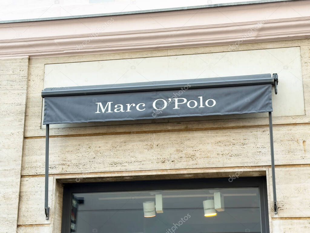 Marc o'polo storefront awning sign on stone building exterior.