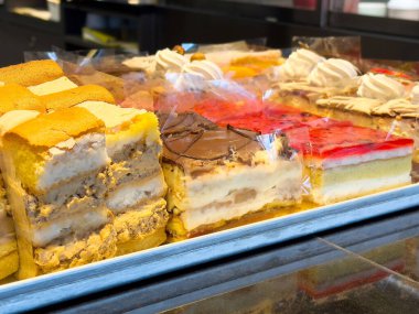 Pastanedeki vitrinde çeşitli katmanlı kekler.