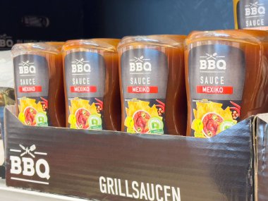 Villach, Avusturya - 17 Nisan 2025: Rafa dizilmiş barbekü sosu şişeleri rengarenk ambalajlarını ve ızgara aşıkları için çekici tasarımlarını vurgula