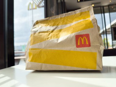 Villach, Avusturya - 17 Nisan 2025: Modern bir restoran ortamında sembolik logo ve parlak renkler sergilenen masa çantası