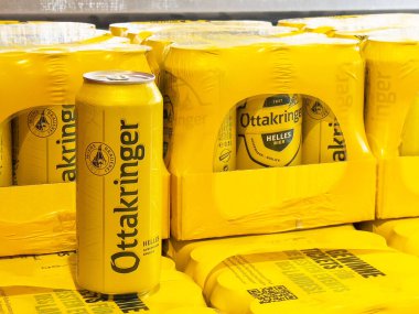 Villach, Avusturya - 17 Nisan 2025: Ottakringer bira kutusu ve paketleri parlak sarıda serinletici içecek markası ve tasarımı vurgulanıyor