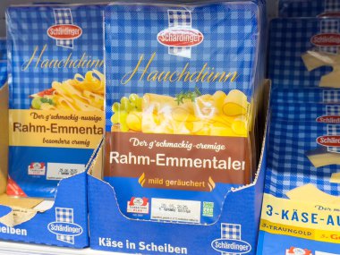 Villach, Avusturya - 17 Nisan 2025: Bir bakkalda peynir ambalajı aşçılık ve sağlıklı yemek için farklı peynir dilimlerini ön plana çıkarıyor