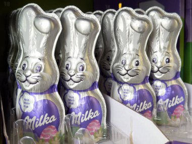 Villach, Avusturya - 17 Nisan 2025: Şenlikli ambalajda çikolatalı tavşan figürleri neşeli kutlamalar için neşeli bir tasarım ve zevkli ziyafetler vurguluyor