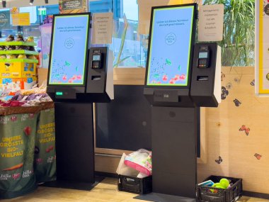 Villach, Avusturya - 17 Nisan 2025: Kişisel hizmet kioskları, modern teknoloji ve kolaylıkların sergilendiği perakende satış alanlarında müşteri etkileşimlerini geliştirmektedir