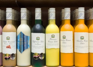 Villach, Avusturya - 17 Nisan 2025: Farklı tatlar ve keyif vermek için sanatsal tasarımlar sergileyen renkli şişelenmiş içecekler