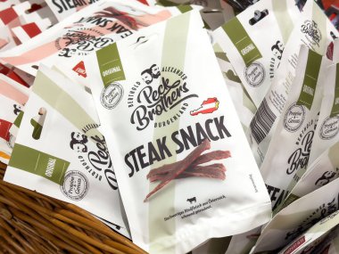 Villach, Avusturya - 17 Nisan 2025: Bir sepete yerleştirilmiş protein zengini biftek çerezi paketleri hızlı yemek için çeşitliliği ve kolaylığı ön plana çıkarıyor