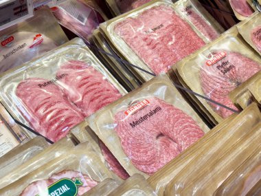 Villach, Avusturya - 17 Nisan 2025: Bir bakkal dükkanında belirlenen paketlenmiş et seçenekleri ve tüketiciler için kalite ve kolaylık