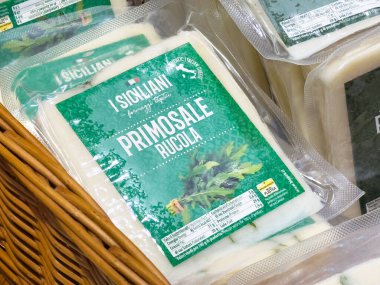 Villach, Avusturya - 17 Nisan 2025: Bir pazar ortamında sunulan roka ambalajlı primosale peyniri sanatsal gıdanın özünü vurguluyor