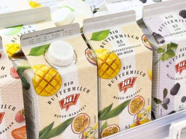 Villach, Avusturya - 17 Nisan 2025: Süt ürünleri alternatiflerinin renkli ambalajı meyve tatlarını ön plana çıkarıyor ve besin seçimlerinde sağlıklı tercihleri teşvik ediyor