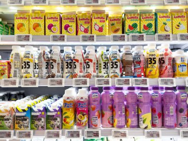 Villach, Avusturya - 17 Nisan 2025: İçecek ambalajı, canlı bir perakende satış ortamında düzenlenmiş çeşitli meyve suyu ve içeceklerin altını çiziyor