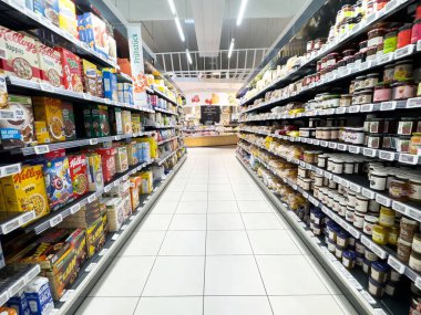 Villach, Avusturya - 17 Nisan 2025: Market koridorunda çok çeşitli gıda ürünleri sergileniyor, çeşitliliğin ve besinlerin erişilebilirliğinin önemi vurgulanıyor
