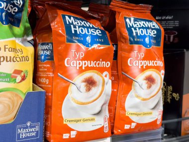 Villach, Avusturya - 17 Nisan 2025: Kahve içecek ambalajı parlak turuncu poşetlerde kapuçino karışımı sergiler ve enfes bir kahve deneyimi sunar