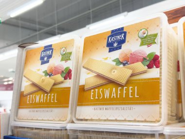 Villach, Avusturya - 17 Nisan 2025: Bir mağazada sunulan canlı aromalı dondurma konisi, mevcut tatlıların çeşitliliğini vurguluyor