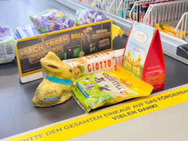 Villach, Avusturya - 17 Nisan 2025: Canlı bir alışveriş ortamında neşe ve beraberliği destekleyen çikolata ikramları ve şenlikli dekorasyonların yer aldığı Paskalya kutlaması