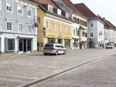 Cobblestone caddesinde renkli binaları ve polis arabası olan Avrupa şehir meydanı.