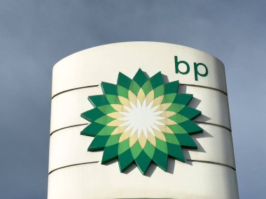 Bulutlu gökyüzüne karşı modern mimari yapı üzerine Bp logosu.