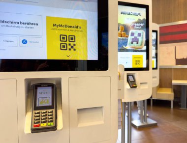 Modern fast food restoranının iç kısımlarında interaktif self servis kioskları.