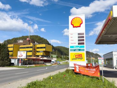 Deniz kabuğu benzin istasyonunda güneşli bir gün ve yol kenarında manzaralı bir yer..