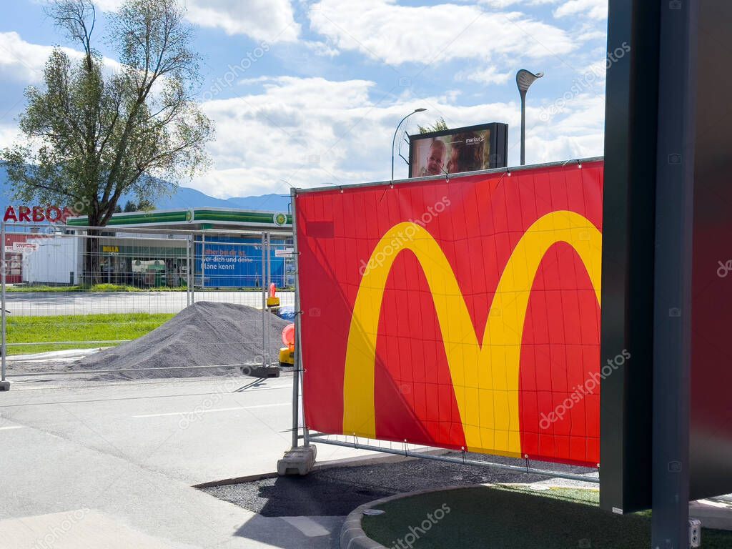 Mcdonald's sign and construction area near gas station on sunny day.