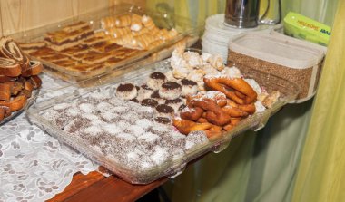 Tepside pudra şekeri ve dantel masa örtüsü ile çeşitli ev yapımı hamur işleri..