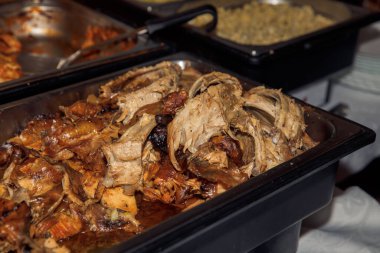 Büfede servis edilen leziz domuz pirzolası ve arka planda pişmiş sebze..