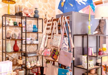 Renkli el çantaları ve ev dekorasyonu rafları ve eşsiz eşyalarla dolu rahat bir butik ortamda..