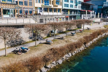 İnsanlar güneşli bir günde nehir kenarındaki güvertede dinleniyorlar..