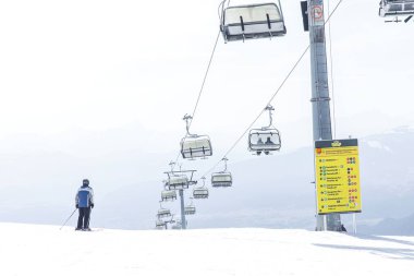 Karlı dağda tek başına kayakçı. Parlak gündüz sahnesinde teleferikli..