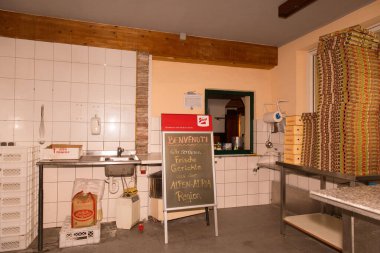 Menü tahtası ve istiflenmiş pizza kutularıyla dolu boş pizzacı mutfağı..