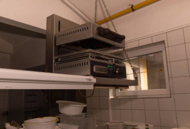 Ticari mutfak tost makinesi, modern ekipmanlarla birlikte profesyonel mutfak ortamında..