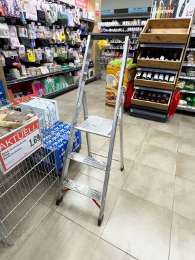 Marketteki rafların önünde merdiven olan boş süpermarket koridoru..