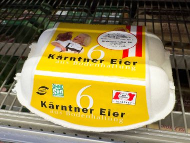 Market rafında sarı ve kırmızı etiketli Avusturya yumurta kartonunda dişi çiftçi.