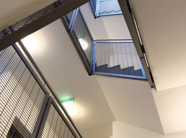 Metal parmaklıkları ve geometrik tasarımı olan modern bir merdiven..