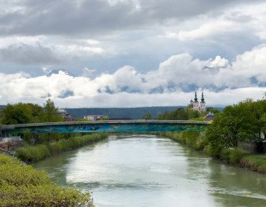 Avrupa 'daki sakin nehir ve kilise bulutlu gökyüzü altında.
