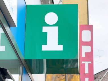 Gözlükçünün kentsel alandaki evinin yanındaki bina duvarında yeşil bilgi işareti.