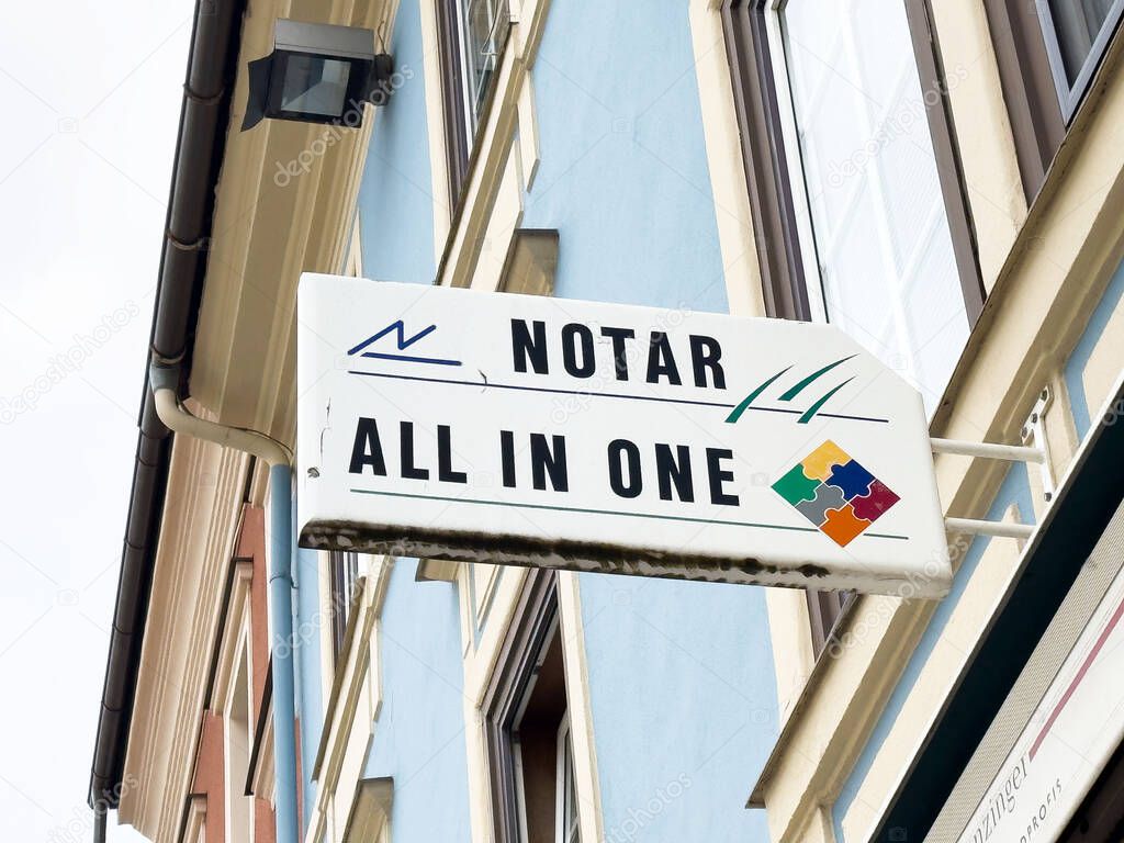 Notar all in one sign on building facade in urban setting.