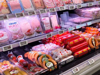 Dondurulmuş süpermarkette paketlenmiş et ve sosis çeşitliliği.
