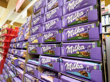 Açık mor ambalajda süpermarket rafında Milka çikolataları sergileniyor.