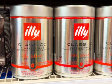 Rafta imzalı kırmızı logo ve italyan metni olan Illy klasik kahve kutuları..