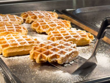 Mutfaktaki metal tepside pudra şekerli taze pişmiş waffle..