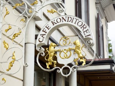 Altın aslanlar ve kraker tasarımlı zarif kafe konditorei tabelası..