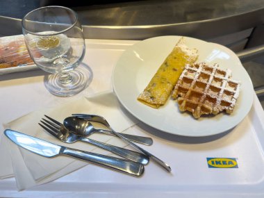 Kafeteryadaki ikea tepsisinde waffle, krep ve cam tabakla..