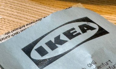 Ahşap arka planda mavi fişin üzerindeki ikea logosunun yakın plan görüntüsü.