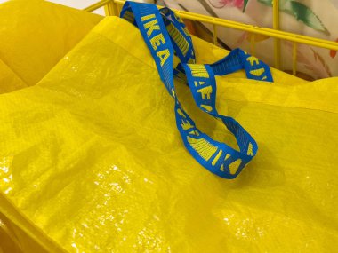 Dükkanda mavi ikea kayışı olan sarı alışveriş çantası.